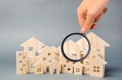 Wooden houses and magnifying glass. Property valuation. Home appraisal. Choice of location for the construction. House searching