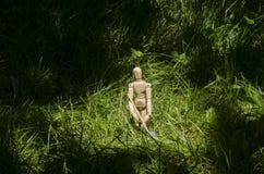 Wooden mannequin in green grass with miniature shovel stock photos Wooden mannequin in green grass with miniature shovel stock photos