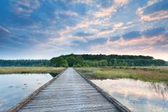 Wooden Path On Lake Water At Sunrise Stock Photo
