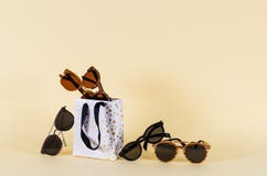 Wooden sunglasses of different design in shopping bag on yellow background. Sunglasses sale concept. Fashion summer accessories. royalty free stock images Wooden sunglasses of different design in shopping bag on yellow background. Sunglasses sale concept. Fashion summer accessories. royalty free stock images