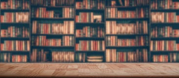 Wooden table in blurred Image Many old books on bookshelf in library