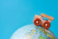 Wooden toy car on a globe on azure background royalty free stock photography Wooden toy car on a globe on azure background royalty free stock photography