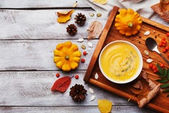 Wooden tray with hot autumn pumpkin soup decorated sesame seeds and thyme in white bowl on rustic vintage table top view. royalty free stock photography Wooden tray with hot autumn pumpkin soup decorated sesame seeds and thyme in white bowl on rustic vintage table top view. royalty free stock photography