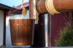 Wooden well. Bucket on a rope Stock Photos Wooden well. Bucket on a rope Stock Photos