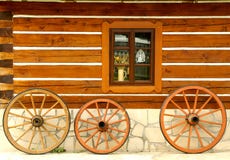 Wooden Wheels At Cottage Wall Royalty Free Stock Image