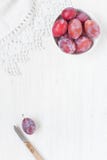 Wooden white table with plums stock photos Wooden white table with plums stock photos