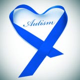 Word autism and blue ribbon forming a heart