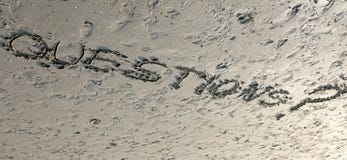 Word QUESTIONS with question mark written on the sand can be use Stock Image Word QUESTIONS with question mark written on the sand can be use Stock Image