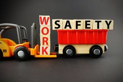 Work safety concept with wooden blocks on orange forklift with dark background stock photo Work safety concept with wooden blocks on orange forklift with dark background stock photo