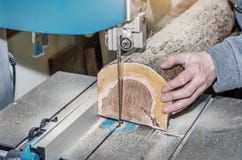 Worker in the carpentry workshop cuts the log into boards using a band saw. Joinery. Raw wood Wooden crafts. Work at the factory