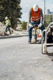 Worker in helmet and reflective vest with drill repairing asphalt royalty free stock photo Worker in helmet and reflective vest with drill repairing asphalt royalty free stock photo
