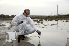 Worker In A Protective Suit Examining Pollution Royalty Free Stock Photos
