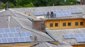 worker installing solar panel roof top apartment