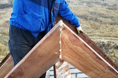 The worker kills the nail in the rafters on top of the roof of the house stock images The worker kills the nail in the rafters on top of the roof of the house stock images