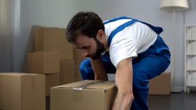 Worker from moving company carrying cardboard box, quality relocation services stock photo Worker from moving company carrying cardboard box, quality relocation services stock photo