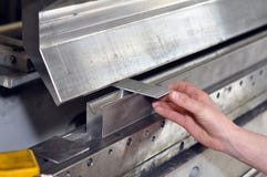 Worker operates bending machine in a metal construction company stock image Worker operates bending machine in a metal construction company stock image