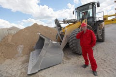 Worker in red uniform on phone at buldozer at construction site royalty free stock photos Worker in red uniform on phone at buldozer at construction site royalty free stock photos