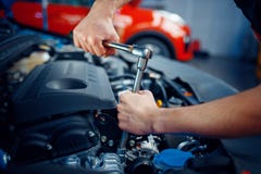 Worker disassembles vehicle engine, car service