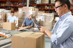 Worker Using Tablet Computer In Distribution Warehouse royalty free stock photos Worker Using Tablet Computer In Distribution Warehouse royalty free stock photos