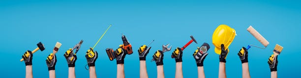 Workers hands with different tools on empty blue background