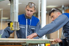 Workers wearing earmuffs using saw stock photography Workers wearing earmuffs using saw stock photography