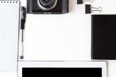 Working office space with a tablet, notepad, camera, external hard disk located on a white table, top view, flat lay stock photography Working office space with a tablet, notepad, camera, external hard disk located on a white table, top view, flat lay stock photography