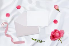 workspace Κάρτες γαμήλιας πρόσκλησης, φάκελοι τεχνών, ρόδινα και κόκκινα τριαντάφυλλα και πράσινα φύλλα στο άσπρο υπόβαθρο σατέν στοκ εικόνα workspace Κάρτες γαμήλιας πρόσκλησης, φάκελοι τεχνών, ρόδινα και κόκκινα τριαντάφυλλα και πράσινα φύλλα στο άσπρο υπόβαθρο σατέν στοκ εικόνα