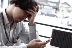 Worried comprimiu o homem de negócios asiático novo que olha o telefone esperto móvel Conceito do negócio da ansiedade Fotos de Stock Worried comprimiu o homem de negócios asiático novo que olha o telefone esperto móvel Conceito do negócio da ansiedade Fotos de Stock