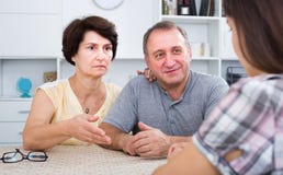 Worried mature family couple listening to young woman stock images Worried mature family couple listening to young woman stock images
