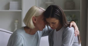 Worried mature mother comforting sad young daughter apologizing reconciling