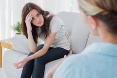 Worried woman sitting and looking at her therapist