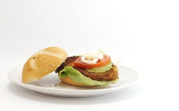 Worstjeschnitzel in een broodje met slatomaat en mayonaise Stock Afbeelding Worstjeschnitzel in een broodje met slatomaat en mayonaise Stock Afbeelding