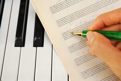Writing on old music score with pen on keyboard