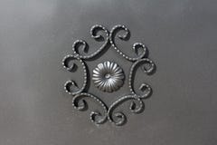 Wrought iron gate ornament on grey metal plate Royalty Free Stock Image Wrought iron gate ornament on grey metal plate Royalty Free Stock Image