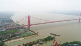 WUHAN, ΚΊΝΑ - 2 ΜΑΐΟΥ 2017: Εναέρια γέφυρα αναστολής κηφήνων τηλεοπτική, κόκκινη με την κυκλοφορία που ρέει απέναντι απόθεμα βίντεο WUHAN, ΚΊΝΑ - 2 ΜΑΐΟΥ 2017: Εναέρια γέφυρα αναστολής κηφήνων τηλεοπτική, κόκκινη με την κυκλοφορία που ρέει απέναντι απόθεμα βίντεο