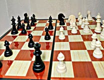 A xadrez é um jogo da lógica da tabela com figuras especiais em uma placa de 64 pilhas para dois rivais, combinando elementos da Imagens de Stock A xadrez é um jogo da lógica da tabela com figuras especiais em uma placa de 64 pilhas para dois rivais, combinando elementos da Imagens de Stock