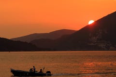 Yacht nei raggi del tramonto contro il backg delle montagne immagine stock libera da diritti Yacht nei raggi del tramonto contro il backg delle montagne immagine stock libera da diritti