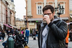 Yang mężczyzna w szkłach z brodą pije kawę zdjęcia stock Yang mężczyzna w szkłach z brodą pije kawę zdjęcia stock