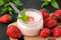 Yaourt d?licieux de fraise dans un pot et des fraises m?res fra?ches et une feuille en bon ?tat sur une table concr?te noire photo stock Yaourt d?licieux de fraise dans un pot et des fraises m?res fra?ches et une feuille en bon ?tat sur une table concr?te noire photo stock