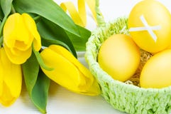 Colorful Easter eggs in green basket and bouquet of tulips on white wooden background. Easter holiday concept stock photos Colorful Easter eggs in green basket and bouquet of tulips on white wooden background. Easter holiday concept stock photos