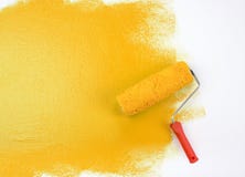 Yellow paint roller. A closeup view of a paint roller applying blue paint to a white object Yellow paint roller. A closeup view of a paint roller applying blue paint to a white object