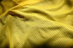 Yellow sport clothing fabric texture background. Top view of yellow cloth textile surface. Bright basketball shirt. Text spac