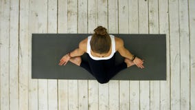 Yoga di pratica della bella giovane donna sportiva, sedentesi nella posizione fornita di gambe trasversale immagini stock libere da diritti Yoga di pratica della bella giovane donna sportiva, sedentesi nella posizione fornita di gambe trasversale immagini stock libere da diritti