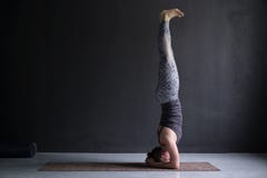 Yoga di pratica della donna, facente esercizio del headstand, posa di sirsasana di salamba fotografie stock Yoga di pratica della donna, facente esercizio del headstand, posa di sirsasana di salamba fotografie stock
