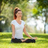 Yoga extérieur La femme heureuse faisant des exercices de yoga, méditent Photographie stock libre de droits Yoga extérieur La femme heureuse faisant des exercices de yoga, méditent Photographie stock libre de droits