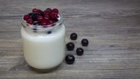 Yogur griego, leche, smoothie con los arándanos y pasas en un tarro de cristal en una tabla de madera, detox, dieta imagenes de archivo Yogur griego, leche, smoothie con los arándanos y pasas en un tarro de cristal en una tabla de madera, detox, dieta imagenes de archivo