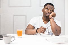 Young African American man falls asleep at breakfast in the kitchen. stock images Young African American man falls asleep at breakfast in the kitchen. stock images