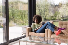 Young african american woman at home using digital tablet royalty free stock images Young african american woman at home using digital tablet royalty free stock images