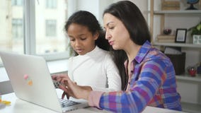 Young afro girl is agree with caucasian tutor in learning online by using new modern technology laptop.