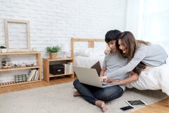 Young asian couple looking at laptop computer to search for travel plan, book hotel room, buy ticket, purchase travel insurance or royalty free stock photos Young asian couple looking at laptop computer to search for travel plan, book hotel room, buy ticket, purchase travel insurance or royalty free stock photos